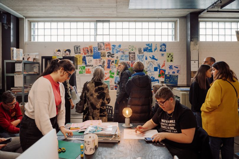 een groep mensen staan voor de risoprinter in Het Lab